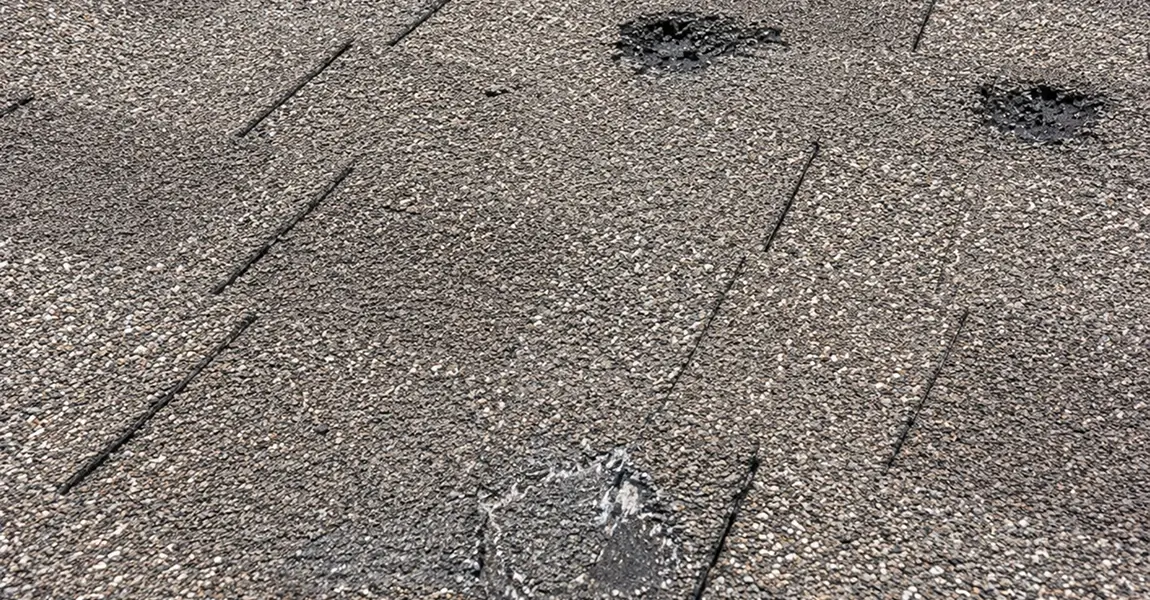 Hail damage Colorado Springs asphalt shingle showing impact bruise and granule loss compared to undamaged shingle
